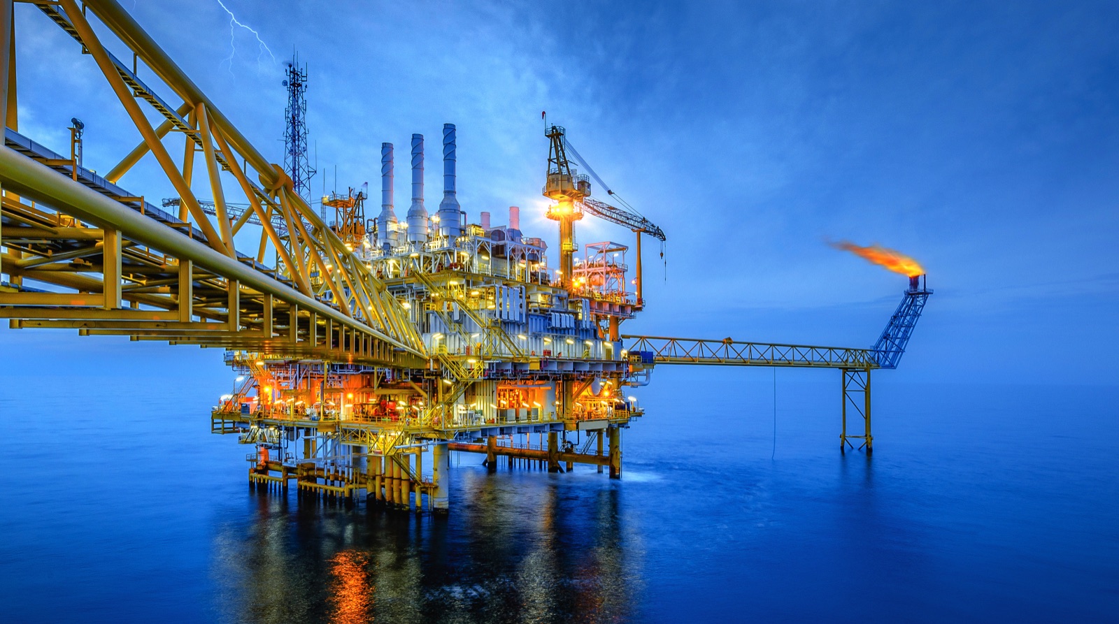 Image showing an offshore oil and gas production platform with a burning flare stack.